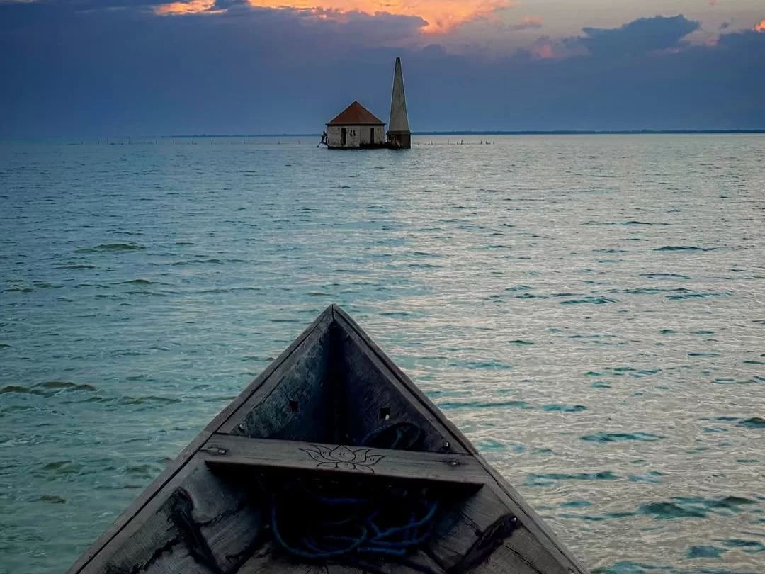 Satapada Dolphin Point Chilika Lake Odisha lighthouse island red roof hut boat prow sunset serene turquoise waters lotus carving, perfect Puri dolphin safari birdwatching tour package. 