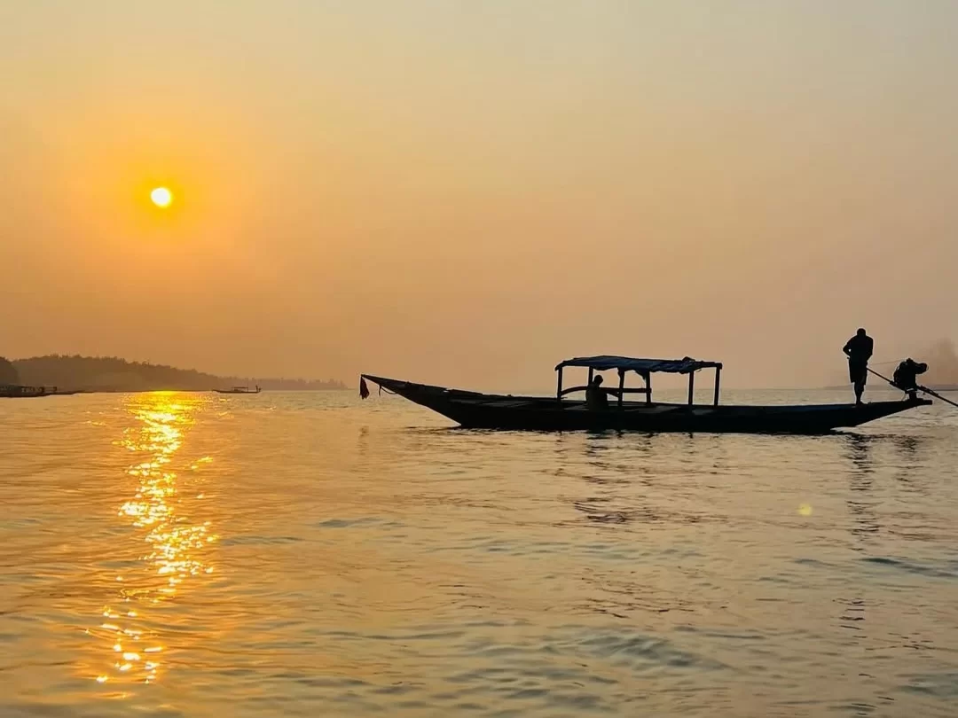 Chilika Lake Odisha traditional thatched boat silhouette sunrise golden hour fisherman serene waters, perfect Puri birdwatching dolphin safari tour package.