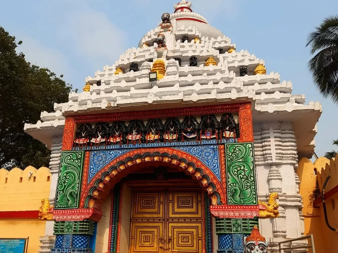 Shree Gundicha Temple entrance at Puri during clear daytime, featuring white spires, colorful deity carvings, ornate arched gate, perfect spiritual experience with Odisha Puri tour package.