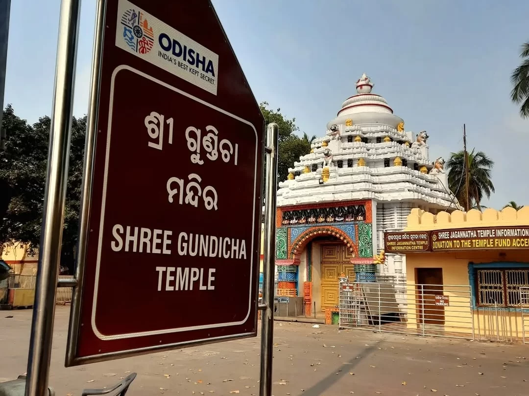 Shree Gundicha Temple sign at Puri during clear daytime, featuring white temple dome, colorful gate carvings, Odisha tourism board, perfect spiritual experience with Odisha Puri tour package.