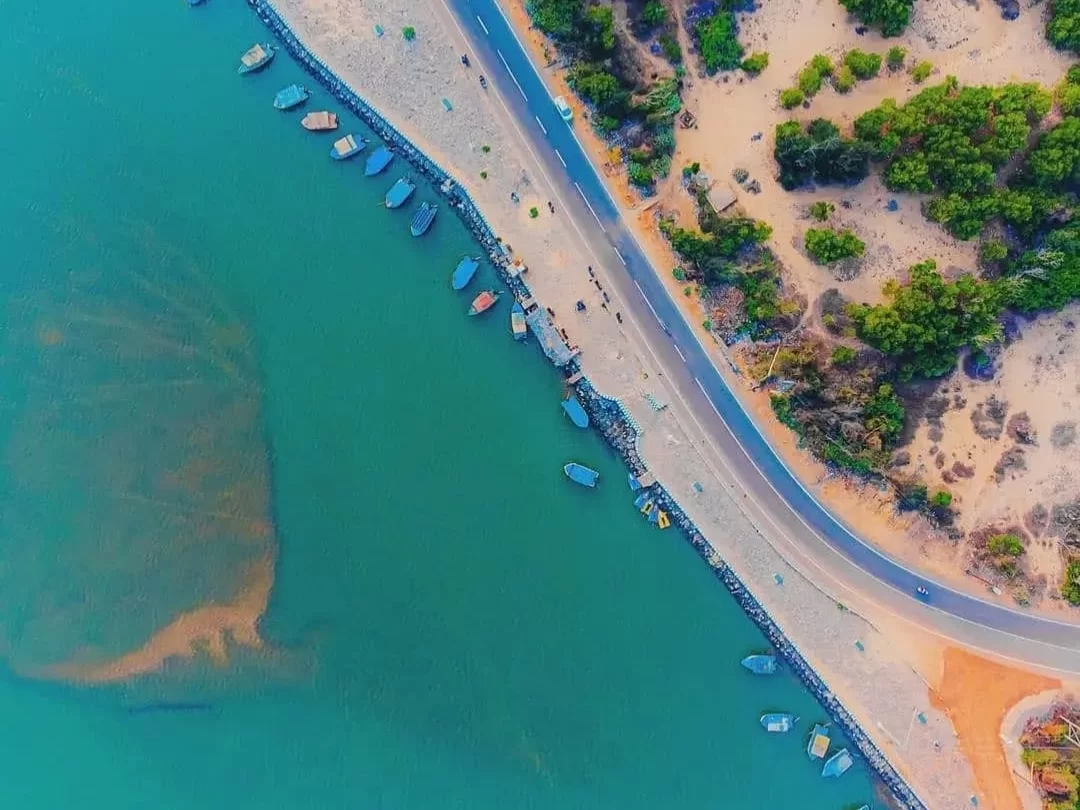 Puri Konark Marine Drive Odisha drone aerial fishing boats turquoise sea sandy shore, scenic coastal highway lush greenery, perfect beach drive golden sands package.