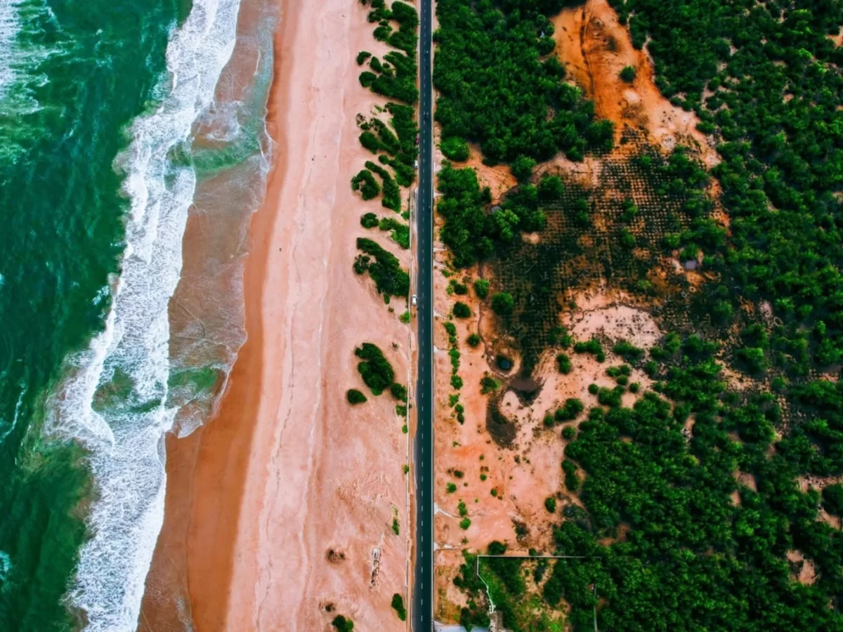 Puri Konark Marine Drive Odisha aerial drone ocean waves golden beach highway palms, scenic coastal road Chilika Lake views, perfect beach drive sunset paradise package. 