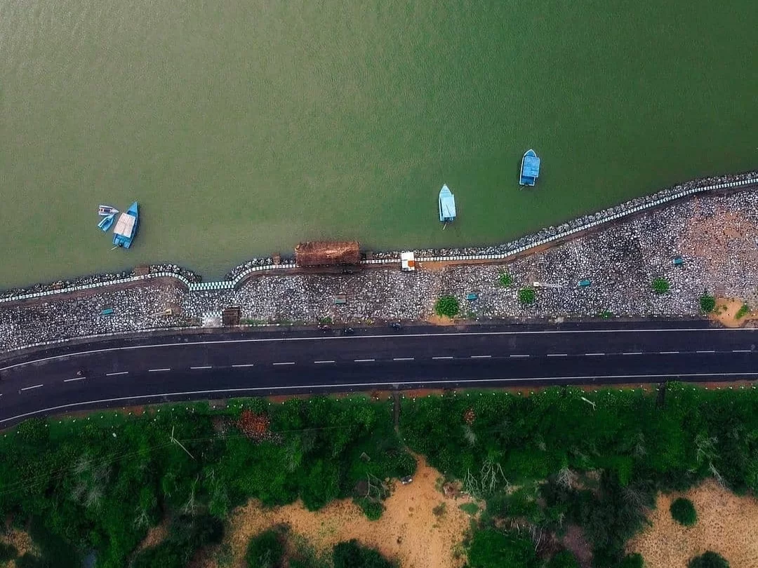 Puri Konark Marine Drive Odisha drone aerial blue fishing boats green lagoon breakwater highway palms, scenic coastal waterway sandy shores, perfect beach drive fishing village package.