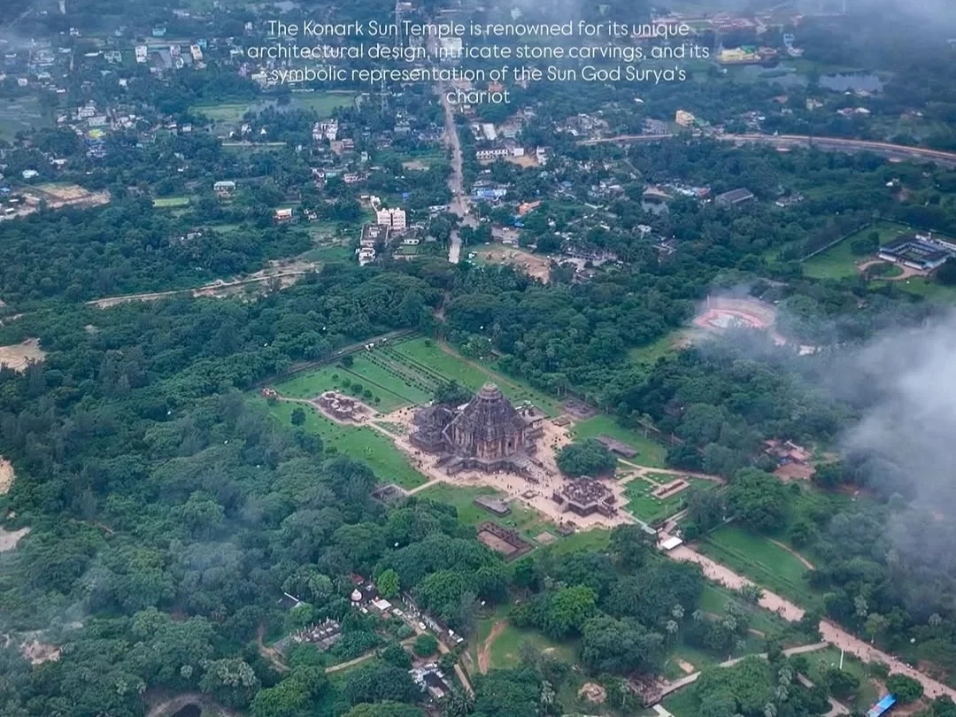 Aerial view of Konark Sun Temple Odisha during misty dawn, featuring chariot wheels, stone carvings, lush forests, village horizon, perfect heritage experience Odisha tour package.