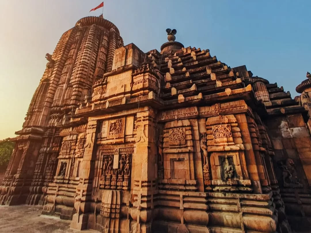 Brahmeswara Temple at Bhubaneswar during golden hour, featuring Odisha flag and Kalinga spires, perfect heritage Bhubaneswar tour package.