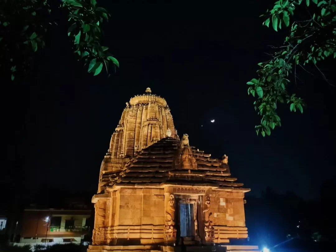 Rajarani Temple Bhubaneswar night illuminated Kalinga vimana foliage moonlit sky golden lights, perfect Odisha heritage temple tour package. 