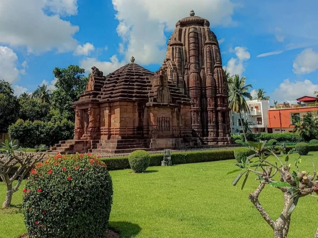 Rajarani Temple Bhubaneswar full view vimana jagamohana red sandstone landscaped garden palms blue sky, perfect Odisha Kalinga heritage tour package. 