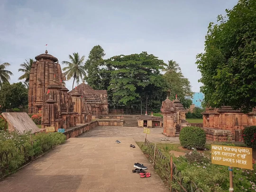 Parsurameswara Temple Bhubaneswar temple courtyard red sandstone shrines palms shoes signboard lush greenery, perfect Odisha Kalinga heritage tour package. 