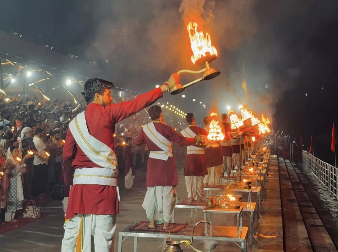 Ganga Aarti ceremony at Triveni Ghat Rishikesh during evening, featuring priests lamps crowd river lights, perfect spiritual experience Uttarakhand tour package.