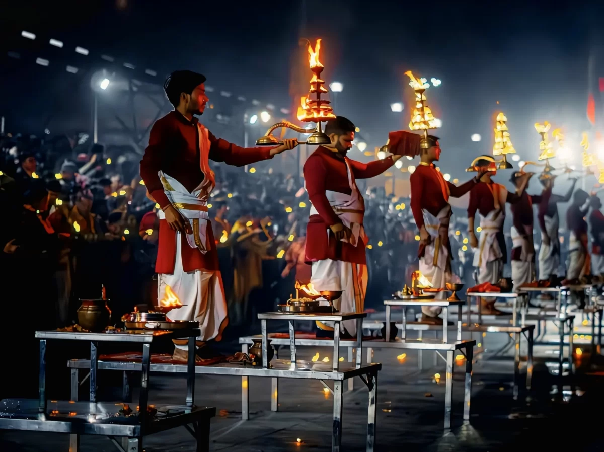 Ganga Aarti ceremony at Triveni Ghat Rishikesh during nighttime, featuring priests flaming lamps brass diyas crowd, perfect spiritual experience Uttarakhand tour package.