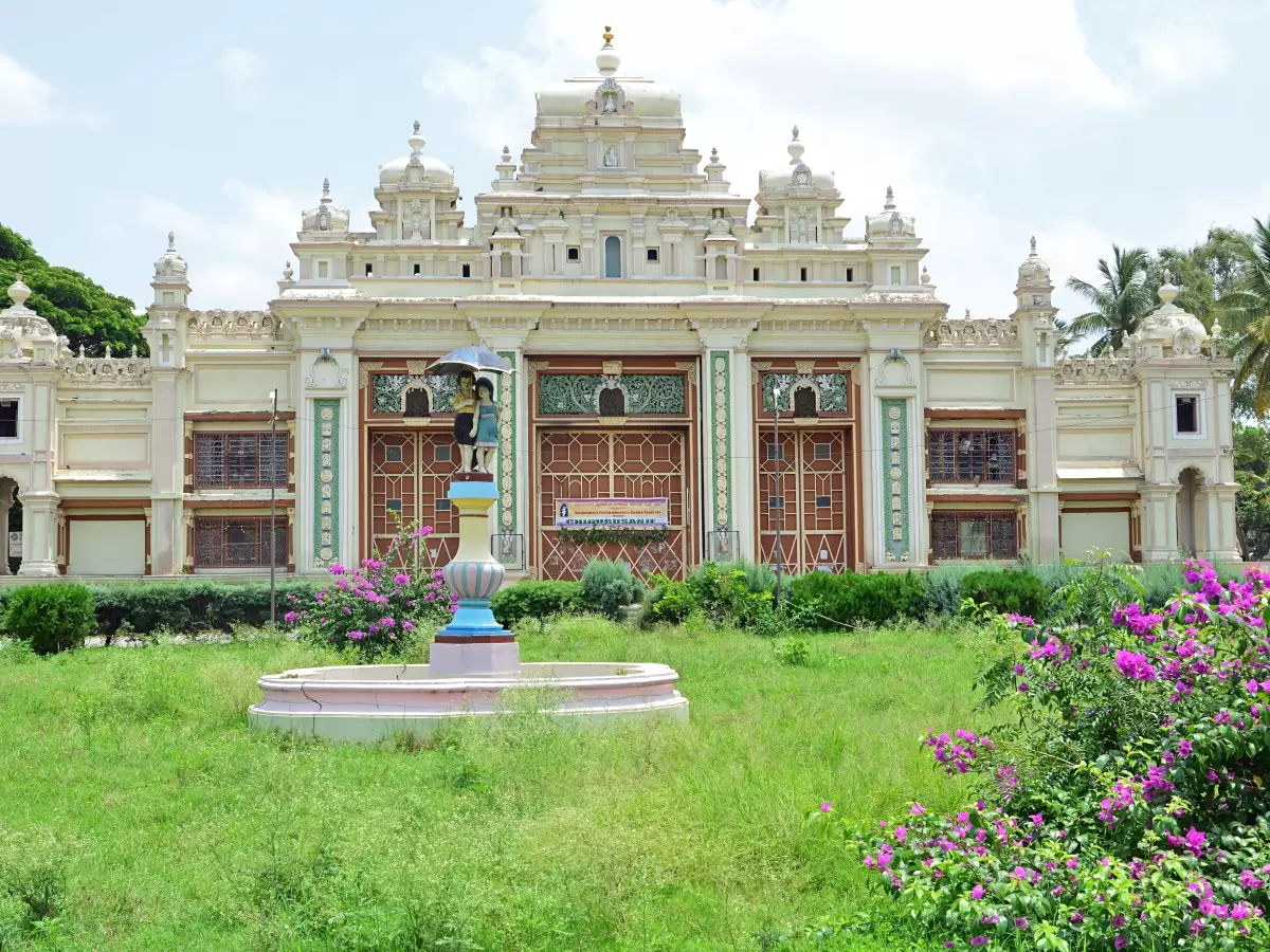 Mysore Palace at Mysore during clear day, featuring ornate Indo-Saracenic architecture gardens fountain bougainvillea, perfect heritage experience Mysore tour package.