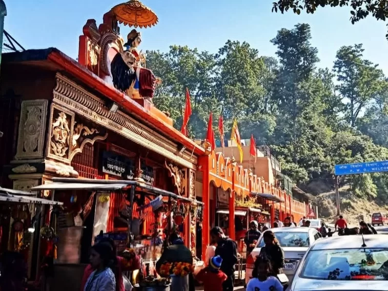 Jai Maa Daat Kali Temple in Dehradun, Uttarakhand with vibrant red façade and devotees offering prayers, a popular roadside shrine included in Uttarakhand tour packages