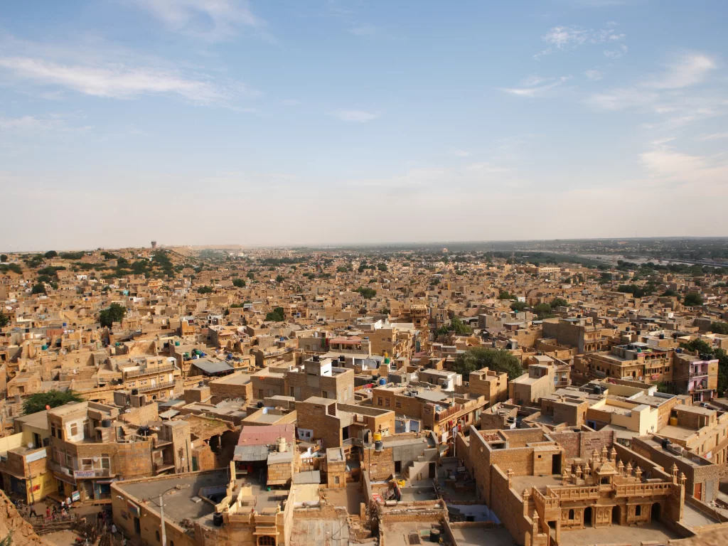 Jaisalmer Fort panoramic view golden havelis sandstone buildings desert town blue sky featured in Rajasthan tour packages.