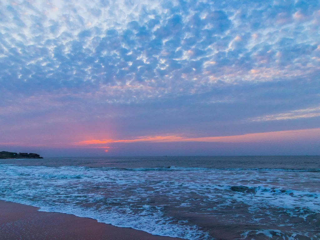 Sunset panorama at Jallandhar Beach Diu during twilight, featuring crashing waves and pink skies, perfect romantic Diu tour package.