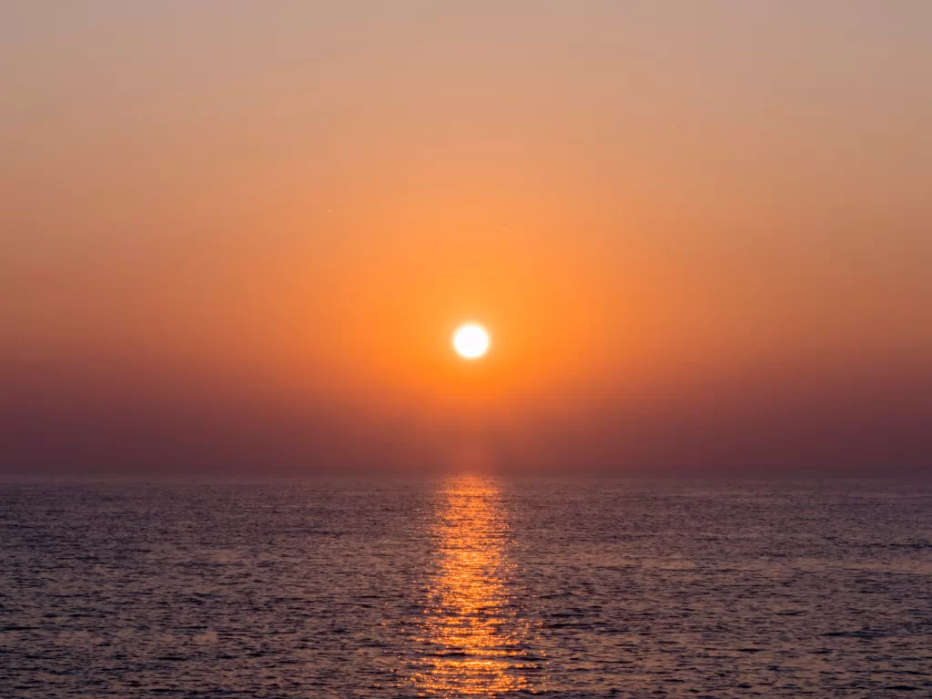 Sunset view at Jallandhar Beach Diu during golden hour, featuring ocean reflections and orange skies, perfect romantic Diu tour package.