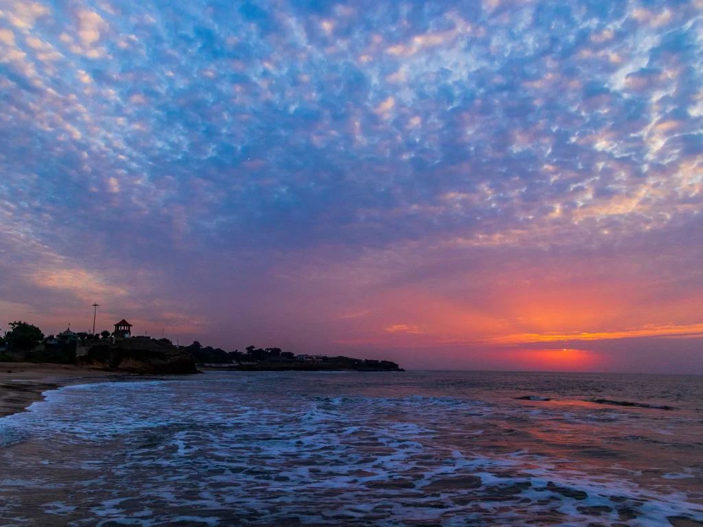 Sunset panorama at Jallandhar Beach Diu during twilight, featuring lighthouse cliffs and golden waves, perfect romantic Diu tour package.