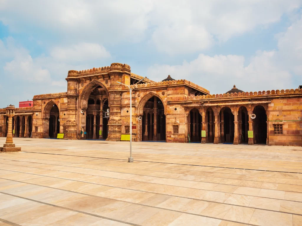 Majestic arches at Jama Masjid Ahmedabad during daylight, featuring sandstone portals and courtyard, perfect cultural Gujarat tour package.