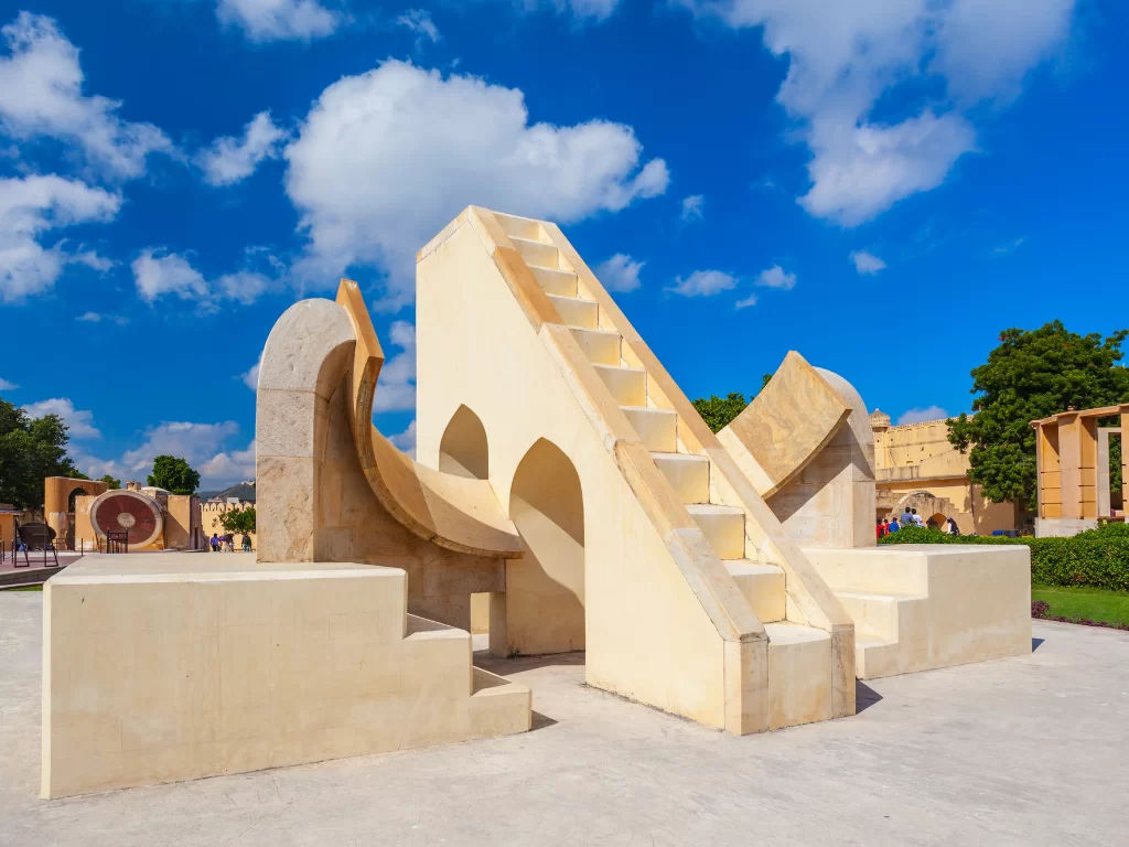 Jantar Mantar at Jaipur under clear blue sky, featuring Samrat Yantra sundial steps arches, perfect heritage experience Jaipur tour package.