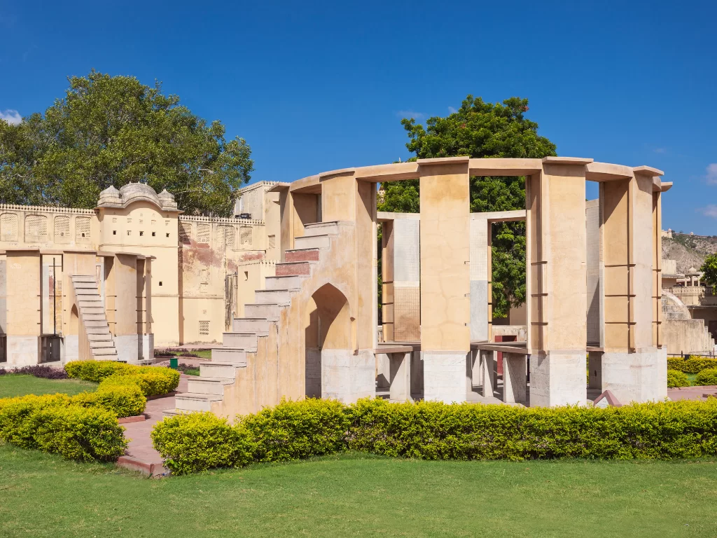 Rashivalaya Yantra at Jantar Mantar Jaipur during sunny day, featuring circular stone structure and gardens, perfect heritage experience Rajasthan tour packages.