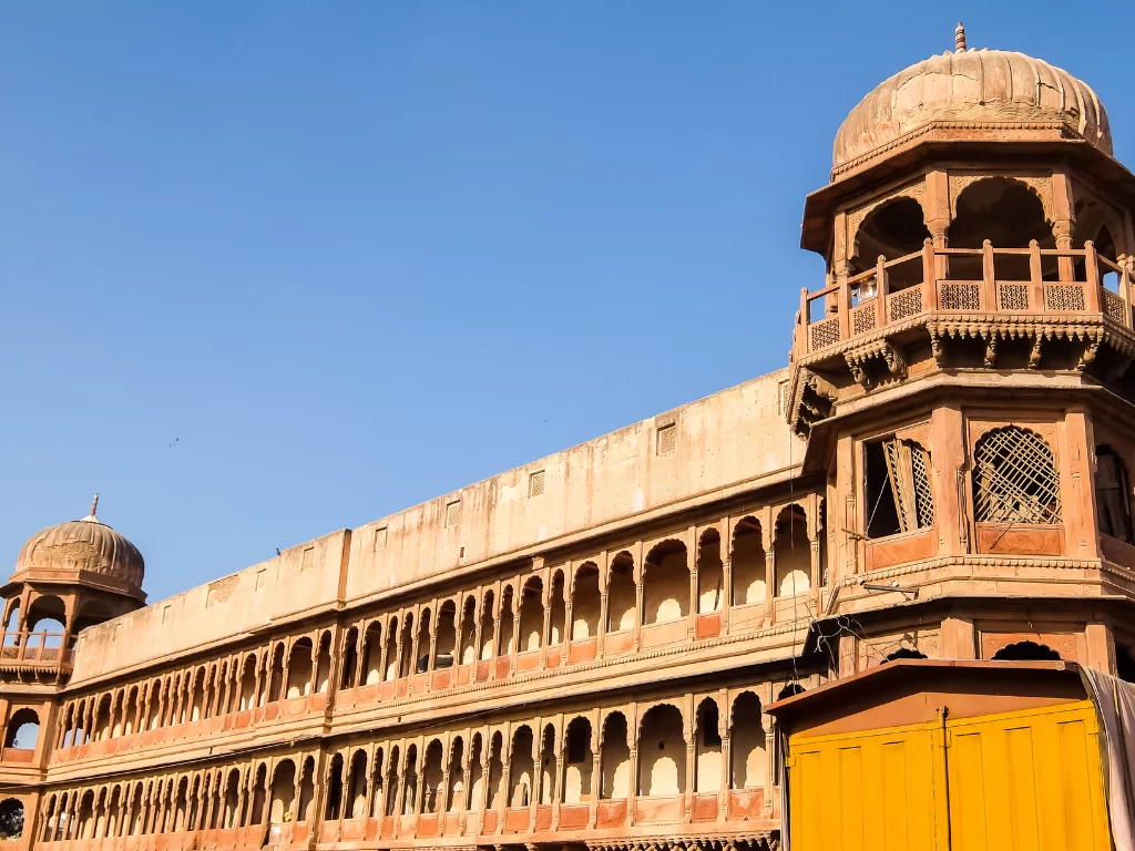 Sunlit ramparts of Junaghar Fort in Bikaner during daytime, featuring arched corridors and domed chhatris, perfect Bikaner fort tour package