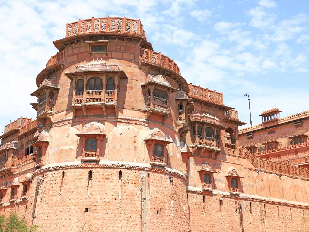 Sunlit bastions of Junaghar Fort in Bikaner during daytime, featuring jharokha balconies and high ramparts, perfect Bikaner fort tour package