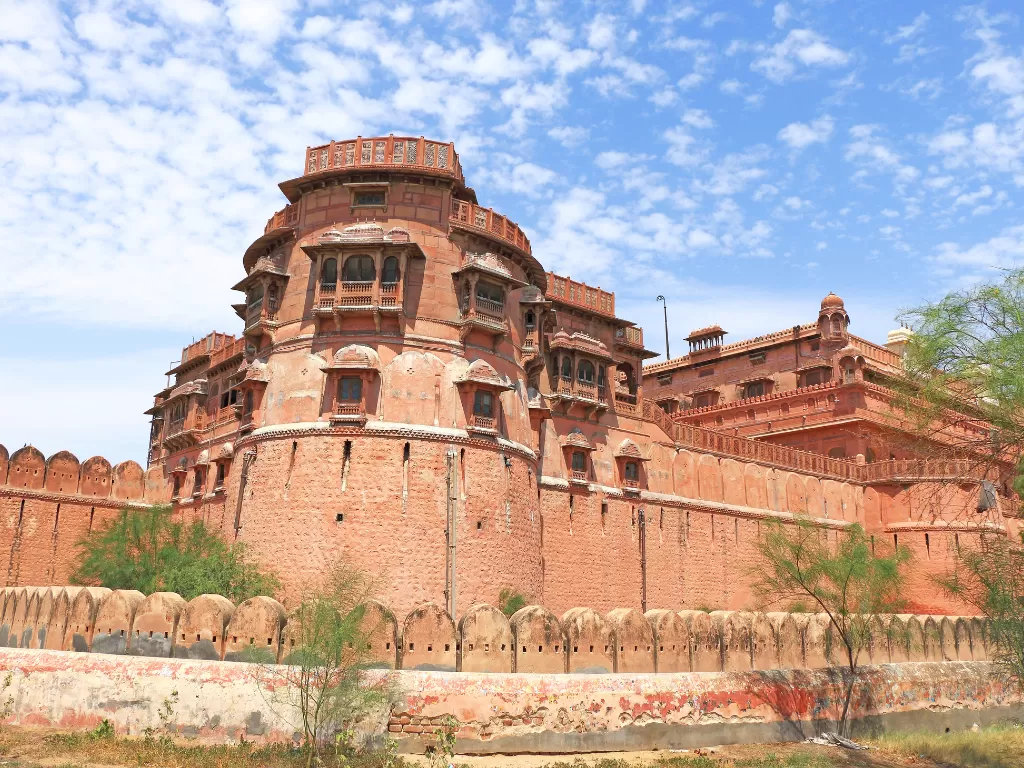 Massive outer walls of Junaghar Fort in Bikaner under blue sky, featuring bastions and jharokha windows, perfect Bikaner fort tour package