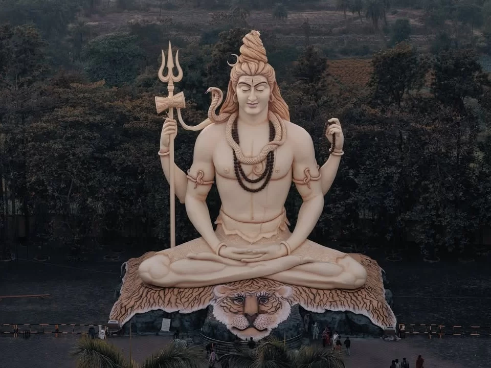 Giant Lord Shiva statue at Kachnar City Shiva Temple in Jabalpur, seated in meditation with trident and tiger-skin base, a prominent spiritual landmark featured in Madhya Pradesh tour packages