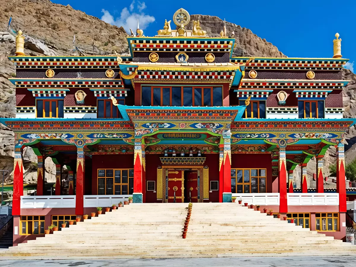 Kalachakra Temple McLeod Ganj Dharamshala Himachal Pradesh, featuring ornate multi-tier Tibetan Buddhist architecture golden roofs colorful murals red doors stairs rocky arid mountain backdrop, perfect cultural experience Himachal tour package.