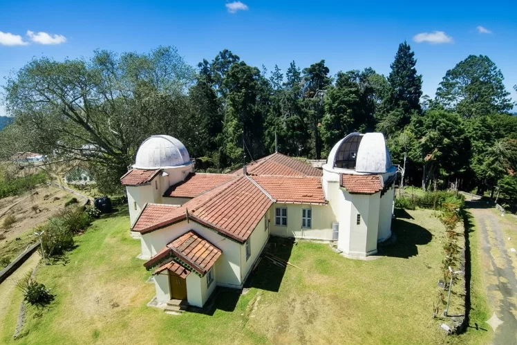 Kodaikanal Solar Observatory Museum featuring a white dome, vintage brass telescopes, and solar charts in the Palani Hills.