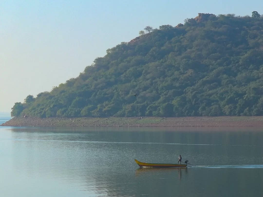 Krishna River Ghat serene riverside view with hills in Andhra Pradesh tour packages.