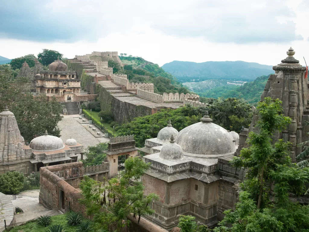 Kumbhalgarh Fort during cloudy weather, featuring dome pavilions, ramparts, shikhara temples, valley views, perfect adventure experience Rajasthan tour packages.