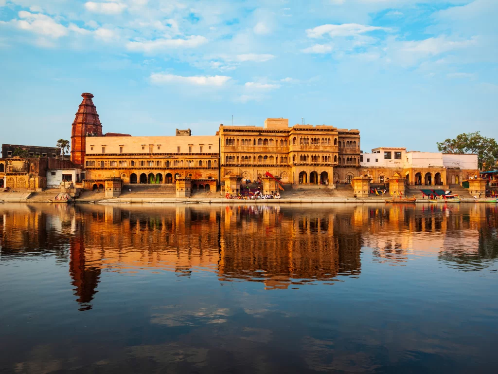 Kusum Sarovar at Mathura during golden hour, featuring sandstone palaces, temple spire, serene lake reflections, perfect spiritual experience with Mathura Vrindavan tour package. 