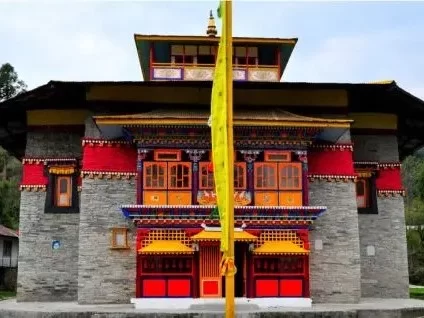 Lachen Monastery Sikkim colorful multi-tiered facade with prayer flags under cloudy sky, perfect cultural North Sikkim tour package.