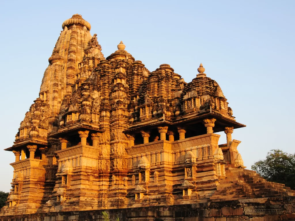 Lakshmana Temple Khajuraho sunset golden hour Western Group UNESCO site, Nagara-style Vaikuntha Vishnu shrine intricate carvings Chandela dynasty 930-950 AD, perfect Madhya Pradesh heritage temple tour package.