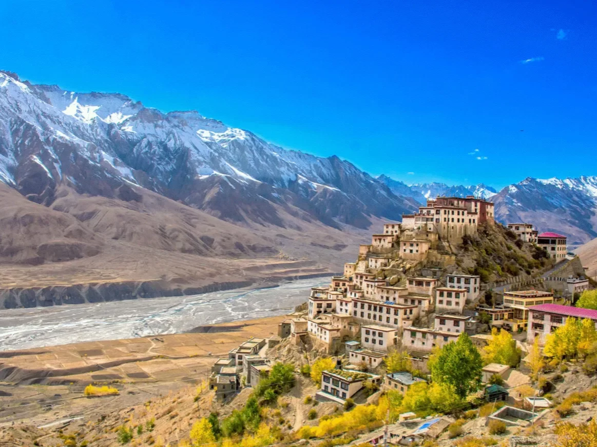 Key Monastery near Langza Village Kaza during clear skies, featuring multi-tiered gompa Spiti river valley snow mountains, perfect cultural experience Himachal tour package.