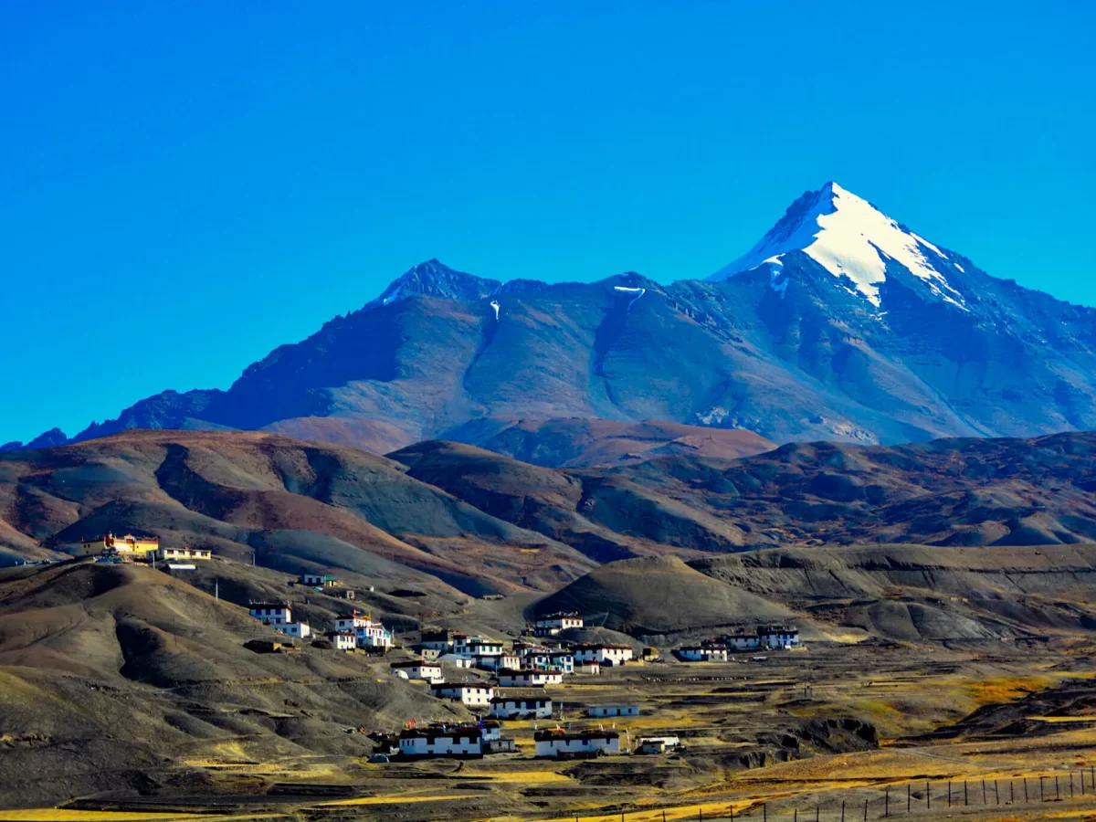 Langza Village near Kaza during clear skies, featuring whitewashed houses prayer flags brown hills Chowri peak, perfect cultural experience Himachal tour package.