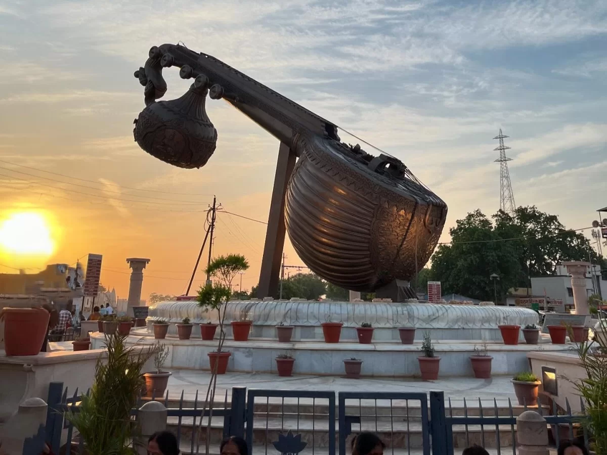 Veena statue at Lata Mangeshkar Chowk Ayodhya during sunset, featuring plants and pedestals, perfect cultural experience Uttar Pradesh Tour Packages.