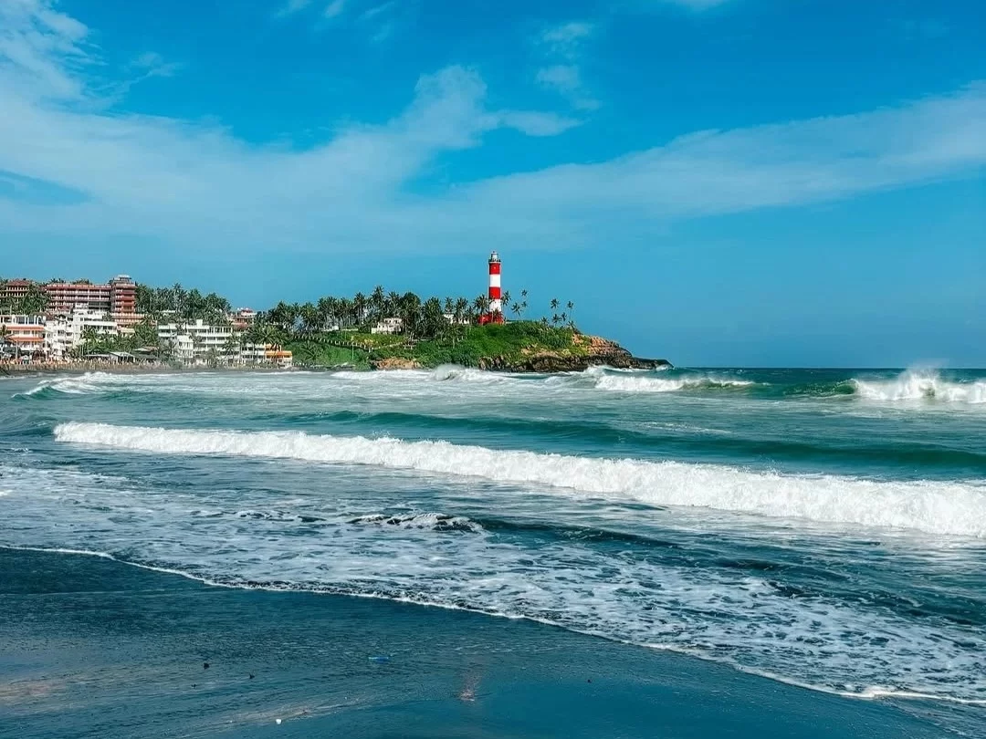 Lighthouse Beach in Kovalam, scenic Arabian Sea shoreline with iconic red and white lighthouse.