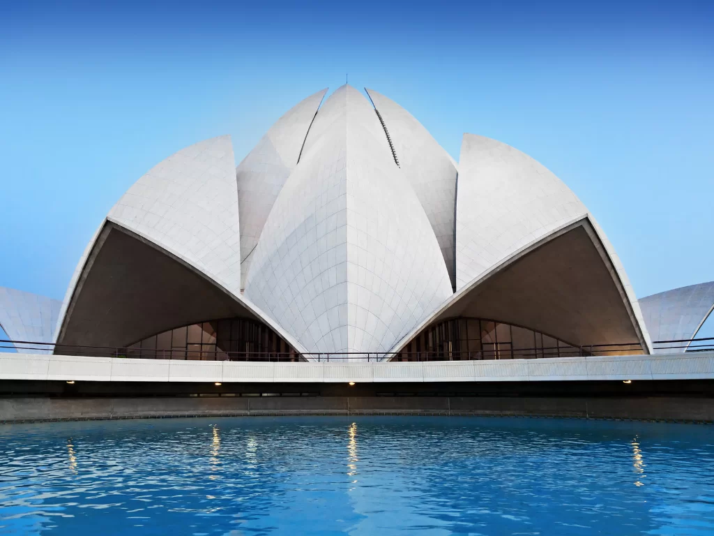 Lotus Temple, New Delhi – elegant white marble lotus petals rising above the tranquil blue reflecting pool, iconic Bahá’í House of Worship and serene highlight of Delhi city tour packages.