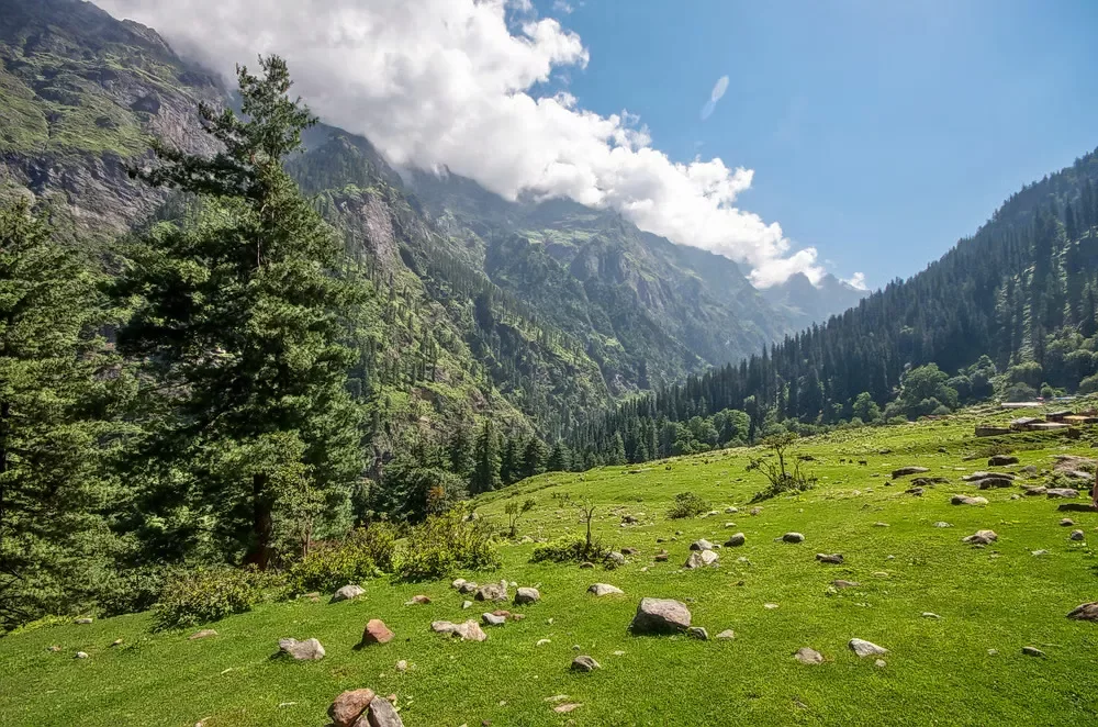 Panoramic Mahasu Peak at Dalhousie during partly cloudy, featuring pine forests, green meadows, Dhauladhar peaks, perfect adventure Himachal Pradesh tour package.