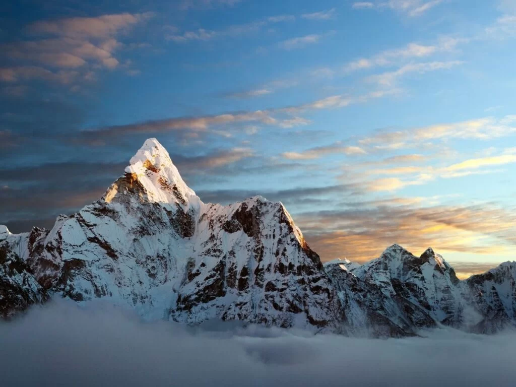 Snow-capped Mahasu Peak at Shimla during winter sunset, featuring dramatic clouds, alpine glow, perfect adventure Himachal Pradesh tour package.