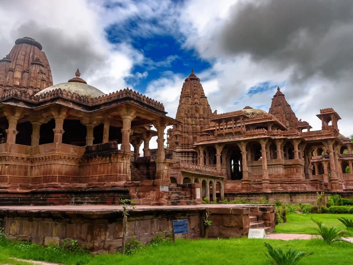 Mandore Garden Jodhpur Historic ruins featuring red sandstone cenotaphs and lush green gardens with high rock walls Rajasthan.