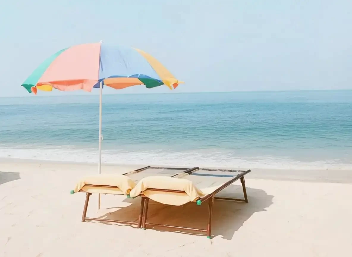 Marari Beach in Kerala, tranquil Arabian Sea shoreline with golden sands and relaxing beach loungers.