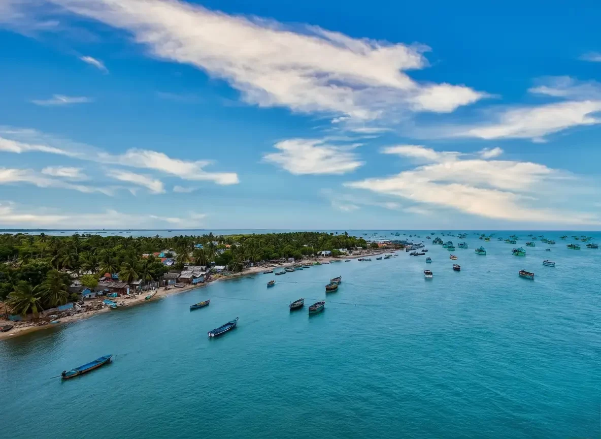 Marina Beach Wide sandy coastline of Marina Beach in Chennai with crashing waves and a lighthouse in the distance.