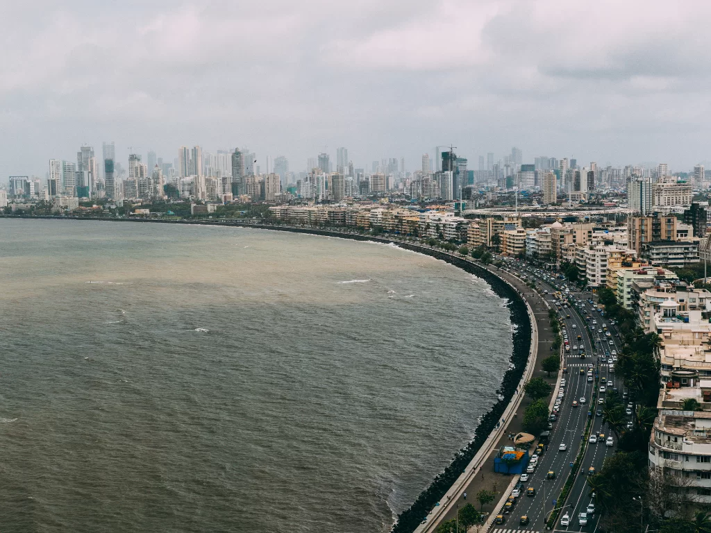 Marine Drive Mumbai aerial view skyscrapers Arabian Sea cloudy sky curving promenade busy traffic urban skyline, perfect South Mumbai walking tour sunset photography package.