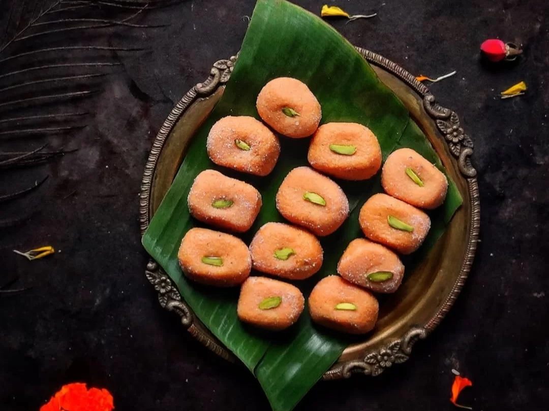 Mathura ke Peda, soft and grainy milk-based sweets from Mathura, delicately flavored with cardamom and garnished with pistachio.