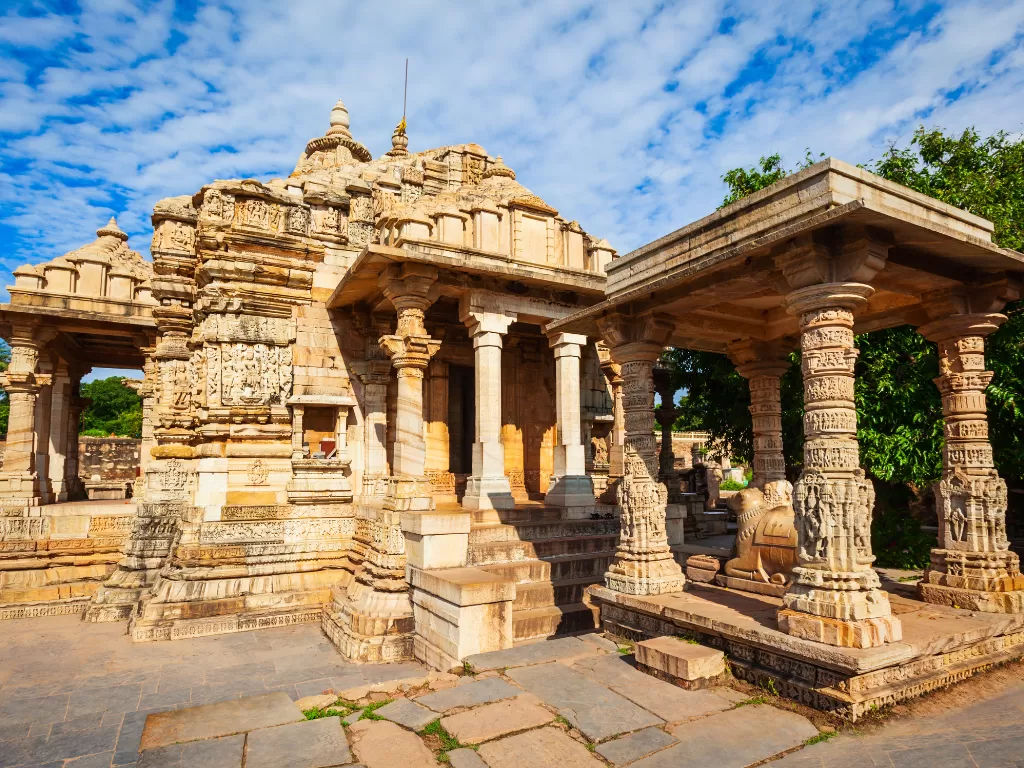 Meera Temple at Chittorgarh Fort in Rajasthan showcasing intricate Indo-Aryan carvings, pillars, and torana with trees, perfect Rajasthan tour package