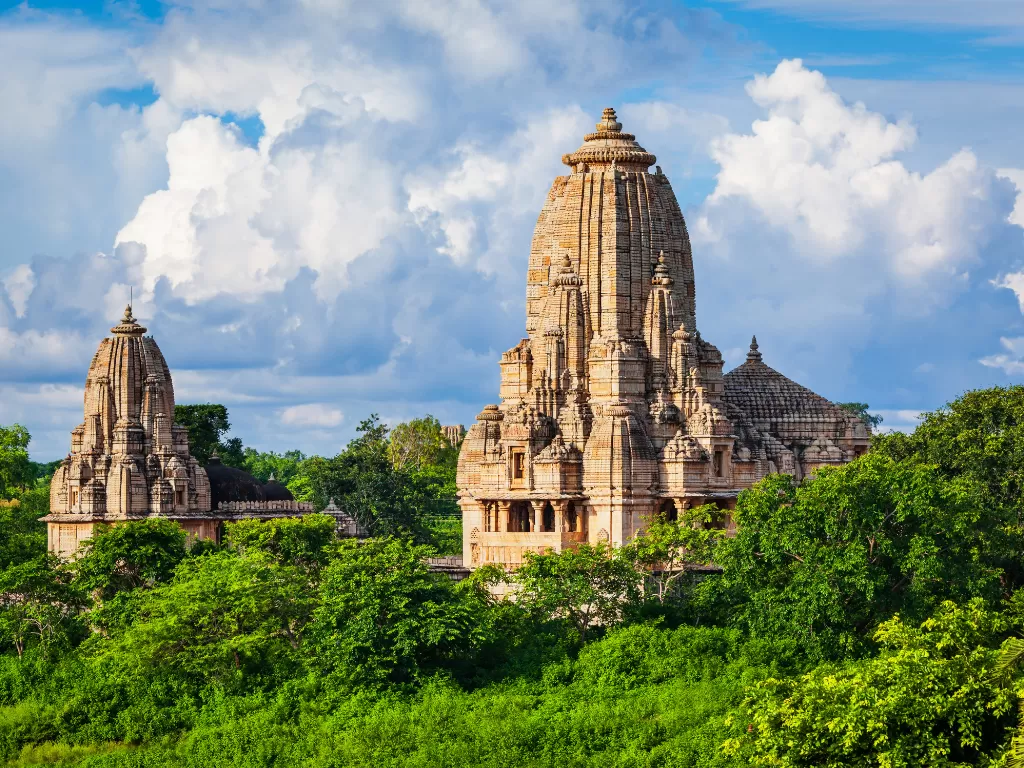 Meera Temple complex at Chittorgarh Fort in Rajasthan with tall shikhara towers amid greenery under partly cloudy sky, perfect Rajasthan tour package