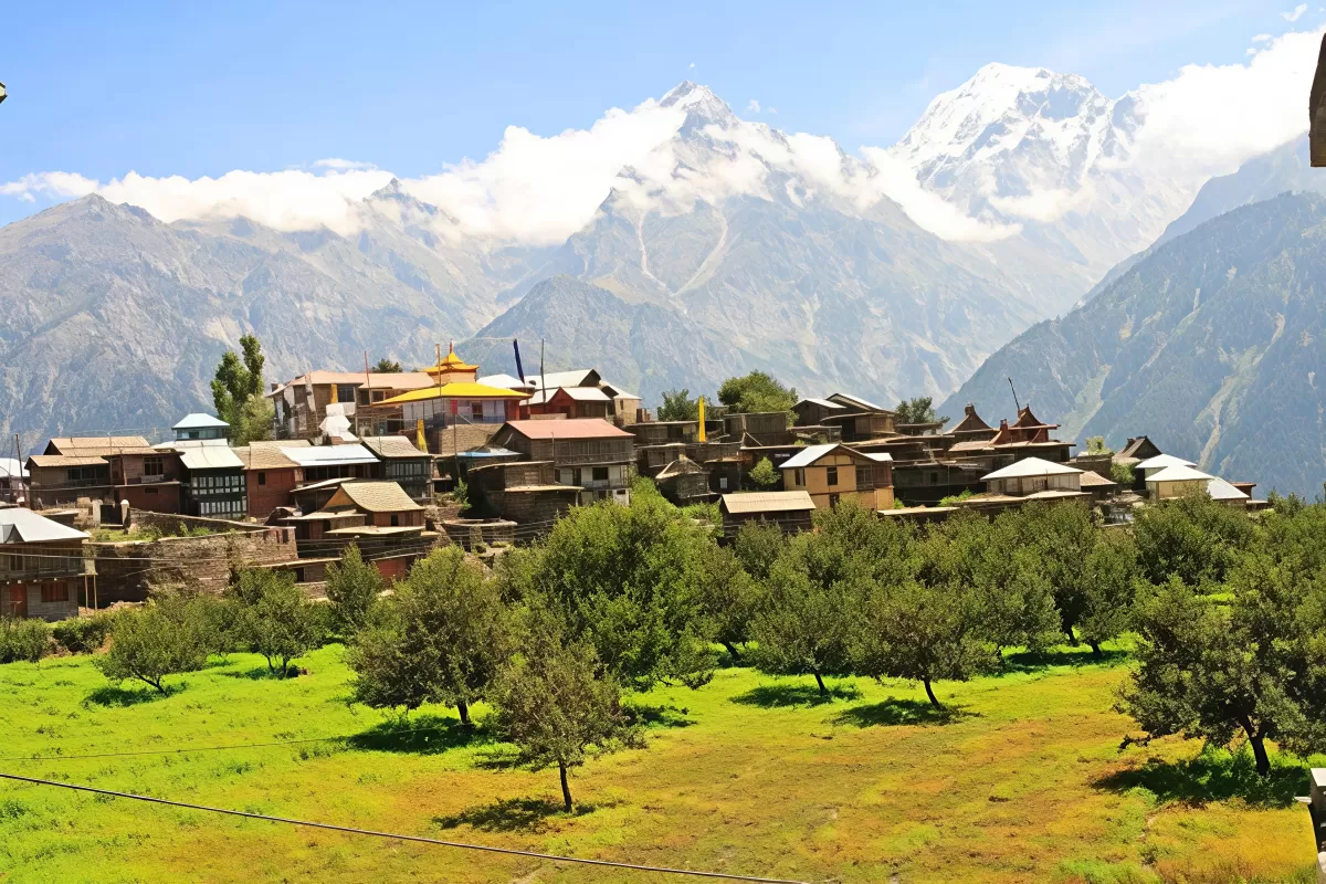 Hu-Bu-Lan-Kar Monastery at Kalpa during clear skies, featuring prayer flags colorful buildings snowy peaks orchards, perfect spiritual experience Himachal tour package.