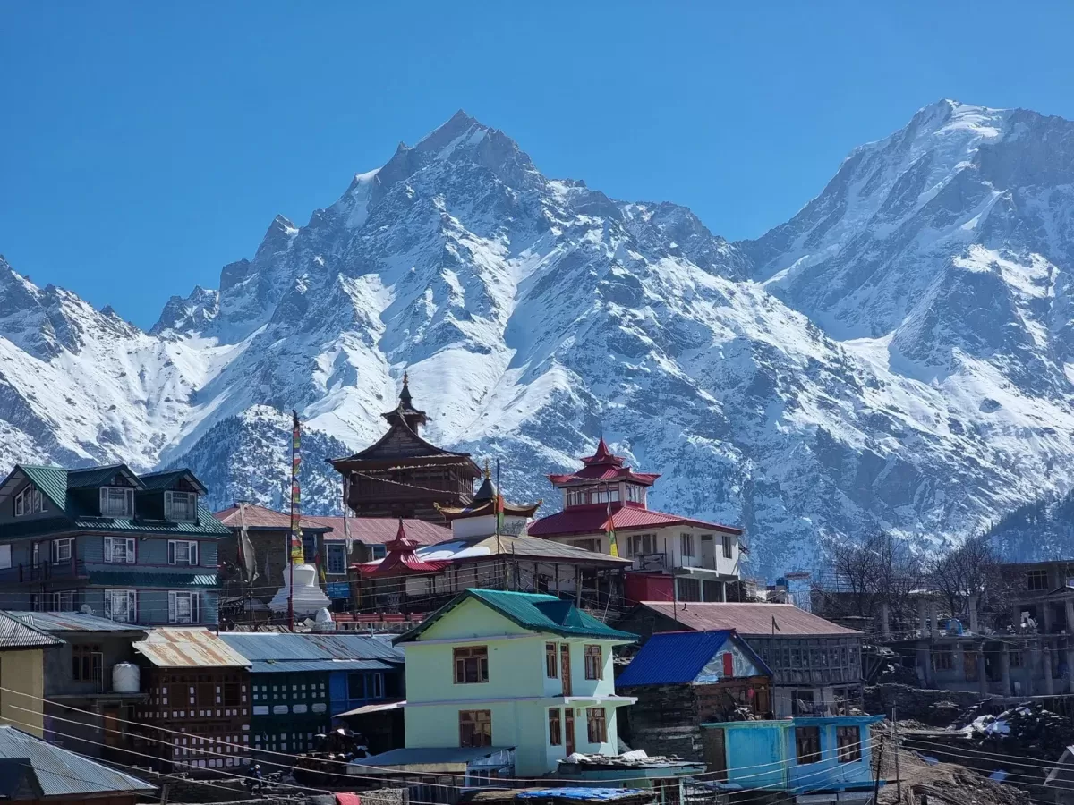Hu-Bu-Lan-Kar Monastery at Kalpa during clear skies, featuring prayer flags colorful buildings Kinnaur Kailash peaks, perfect spiritual experience Himachal tour package.
